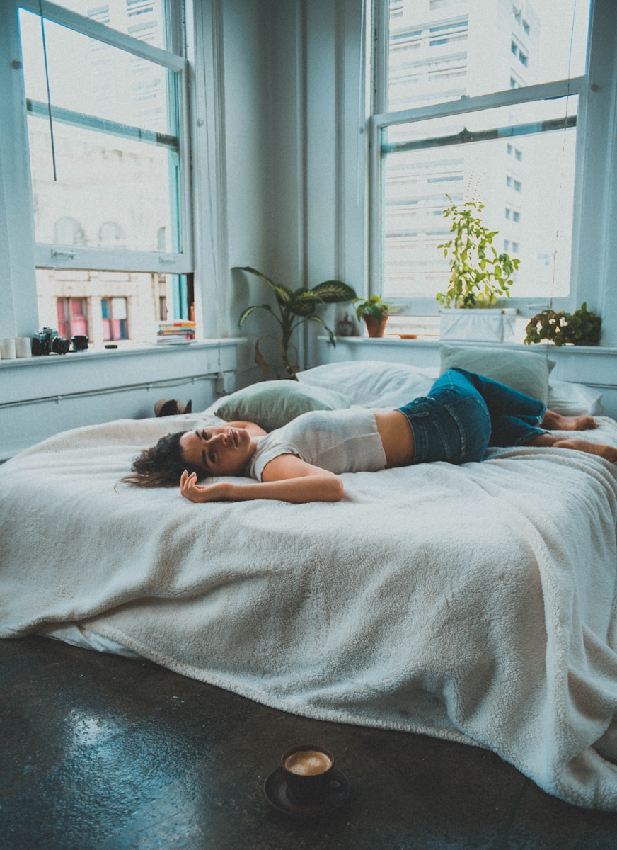 woman in blue denim shorts lying on bed