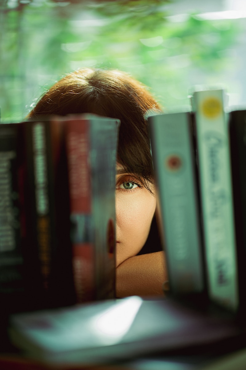 A woman peeking out from behind a bookshelf